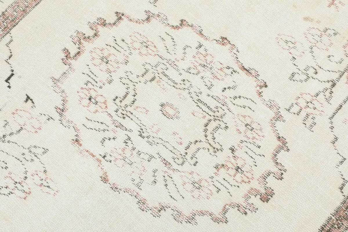 Detail view of the central medallion design on the ivory field of the rug