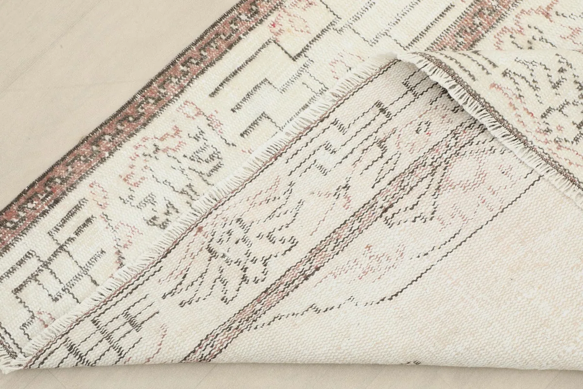 View of the rug's underside, revealing the hand-knotted cotton foundation and wool pile