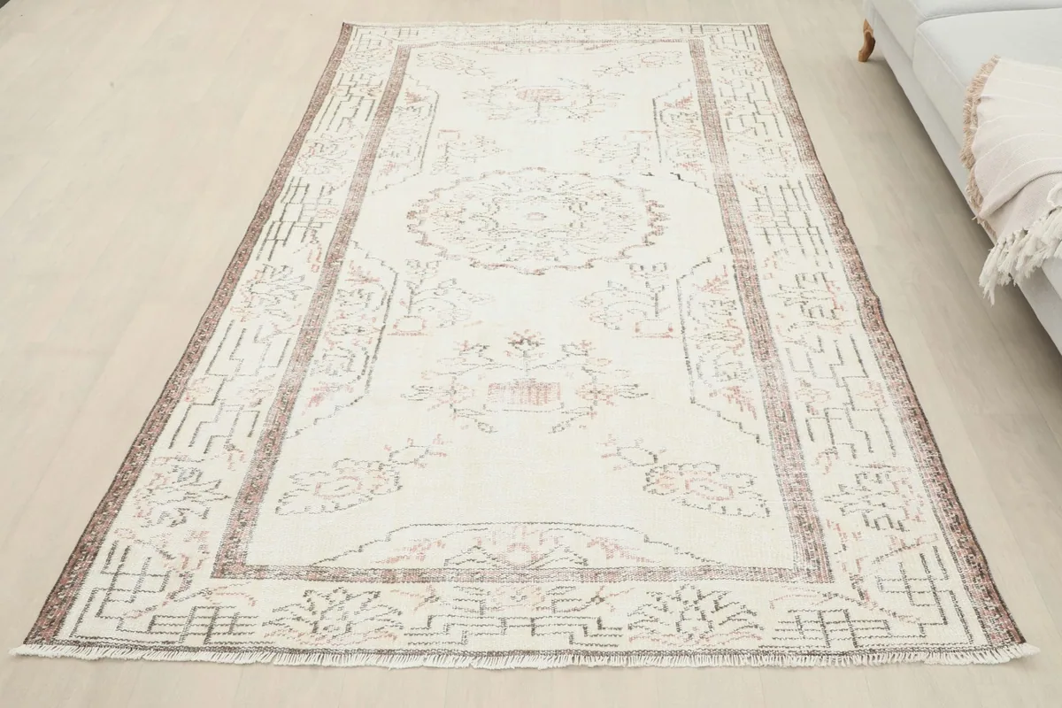 Overhead view of the ivory and rust vintage rug laid out on a light-colored floor