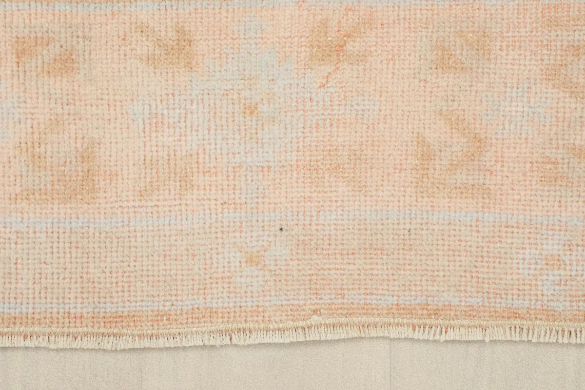 Close-up of the rug's short, natural fringes and the texture of the wool pile