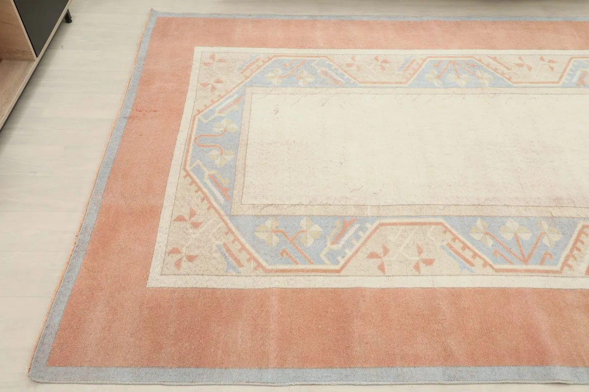 Corner view of the rug, showing the blend of rust, ivory, blue, and beige colors