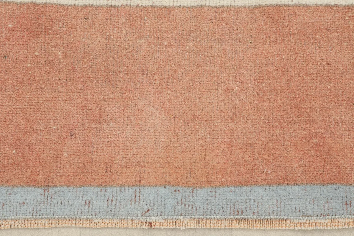 Close-up view of the low wool pile and texture of the rust and blue sections