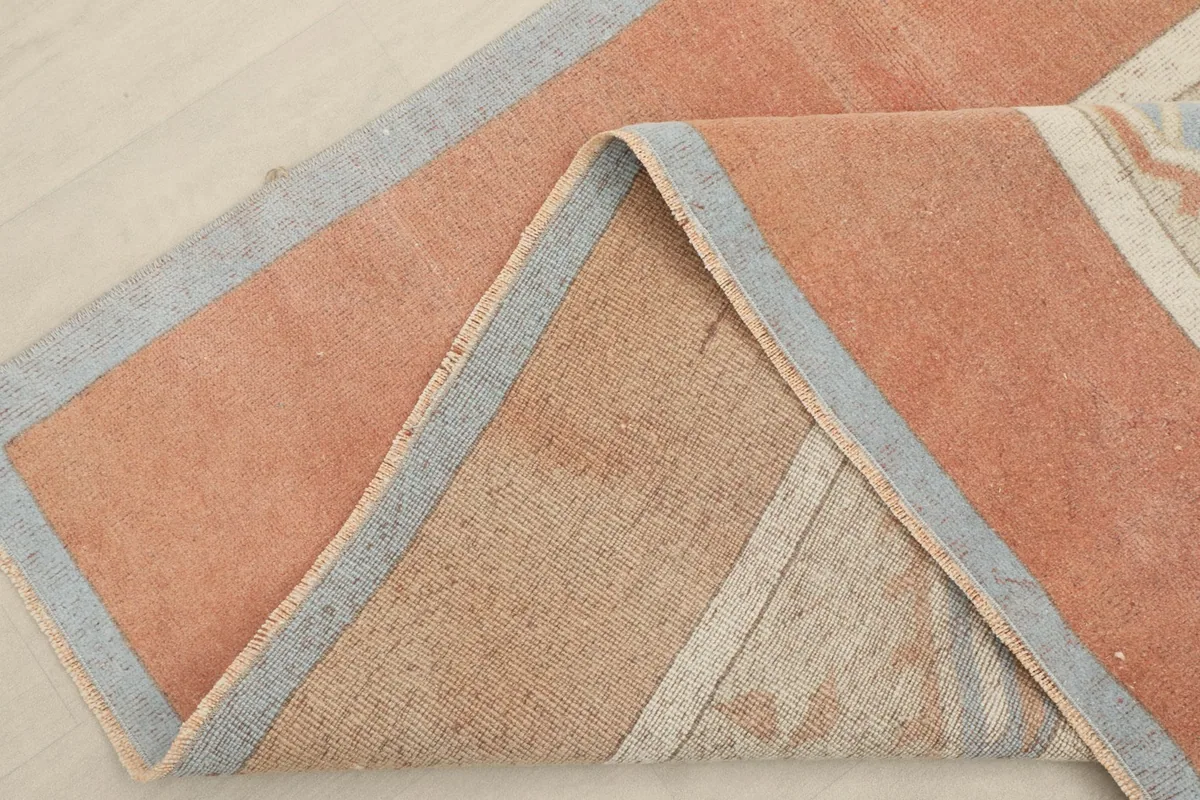 Folded corner of the rug, revealing the cotton foundation and back of the hand-knotted weave
