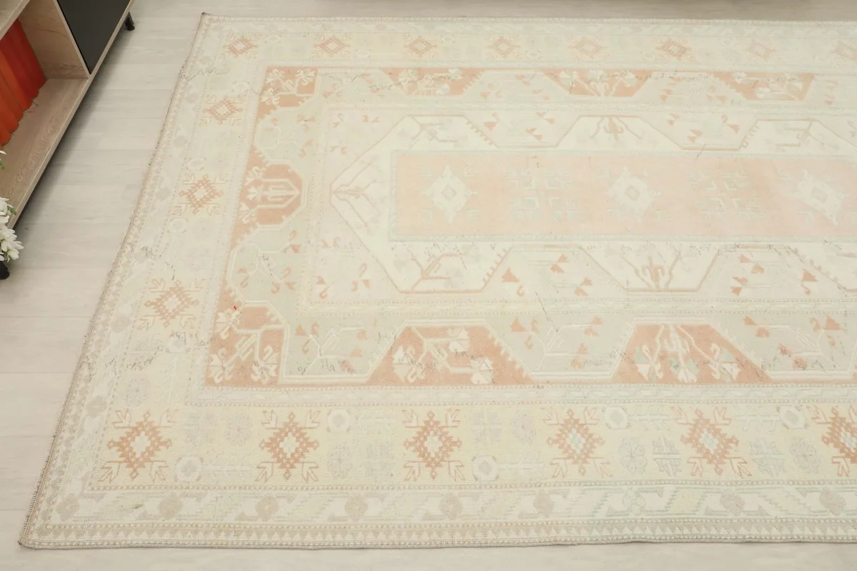 View of another corner of the rug, detailing the faded orange geometric motifs