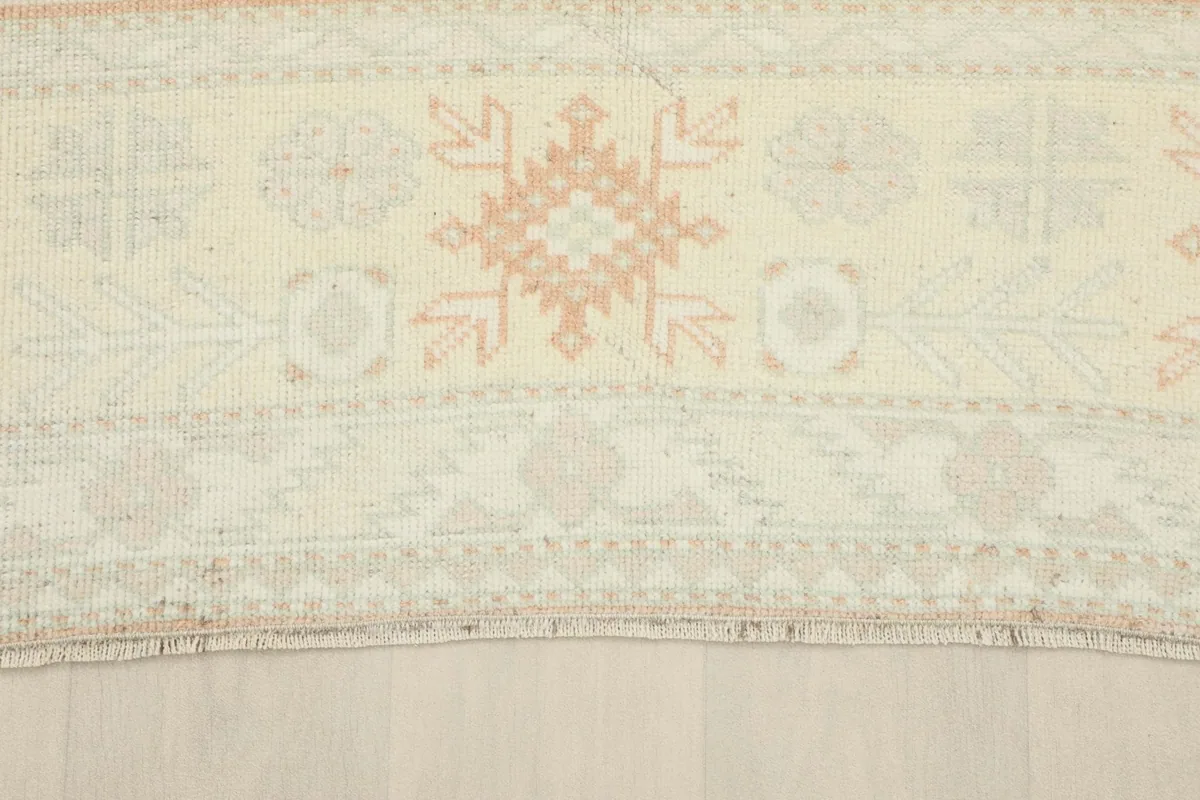 Detail of the rug's outer border with geometric designs and subtle color variations