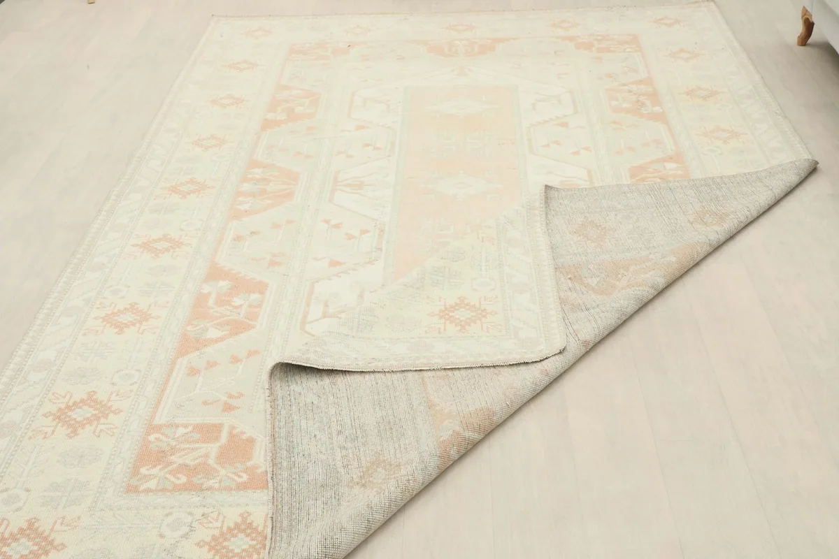 Overhead view with a corner folded back, revealing the rug's construction and foundation