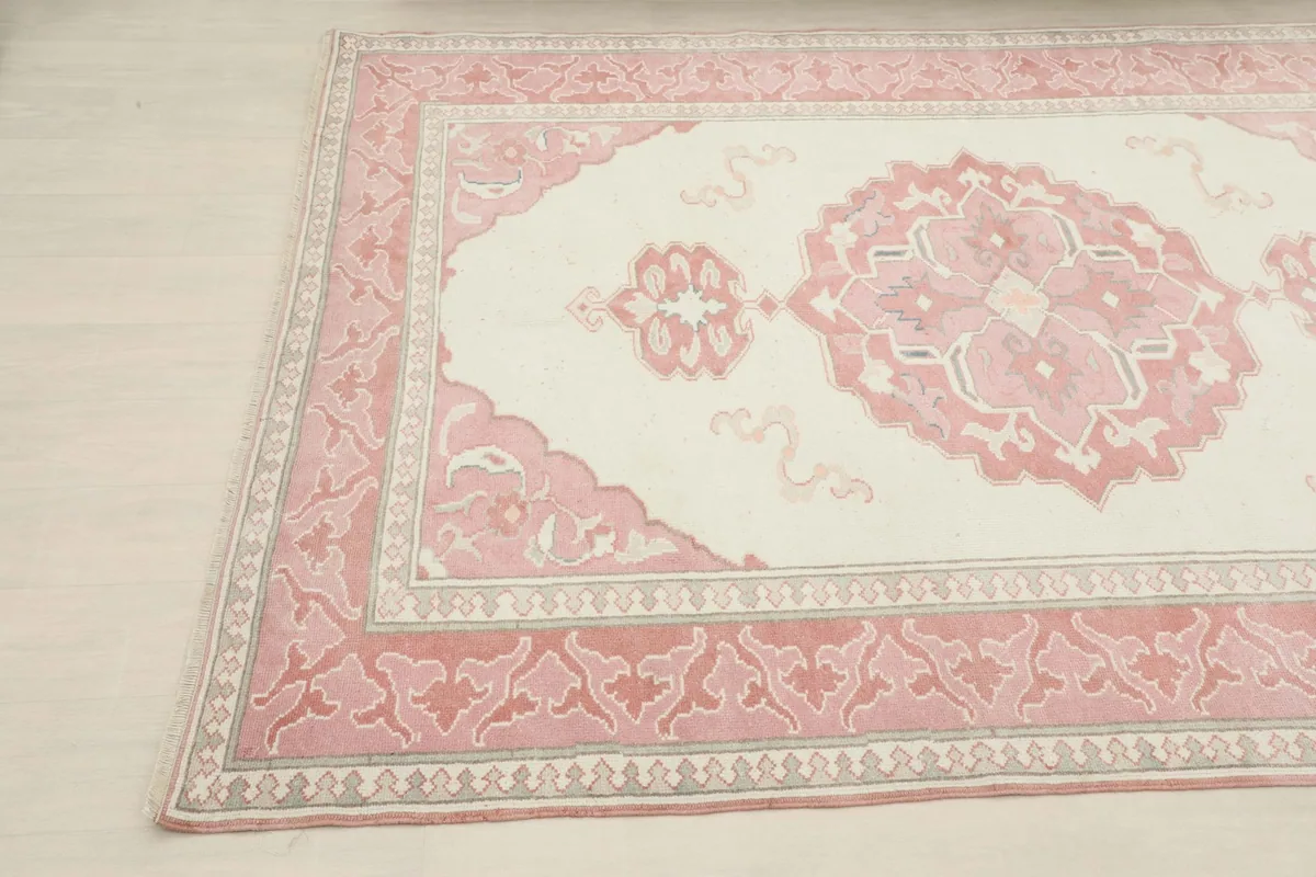 Detailed angled shot of the rug's pattern, showing the intricate rose and ivory motifs.