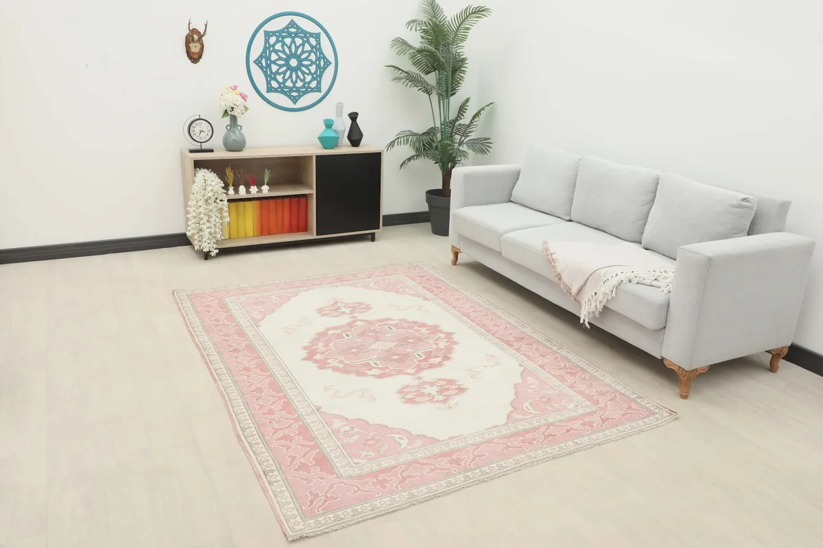 Vintage Anatolian rug displayed in a living room setting with a light gray sofa and modern decor.