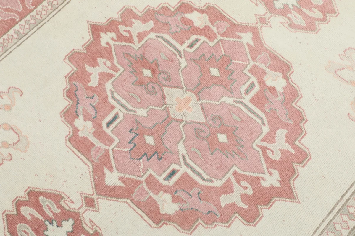 Close-up detail of the central rose medallion, showing the hand-knotted wool texture and subtle color variations.