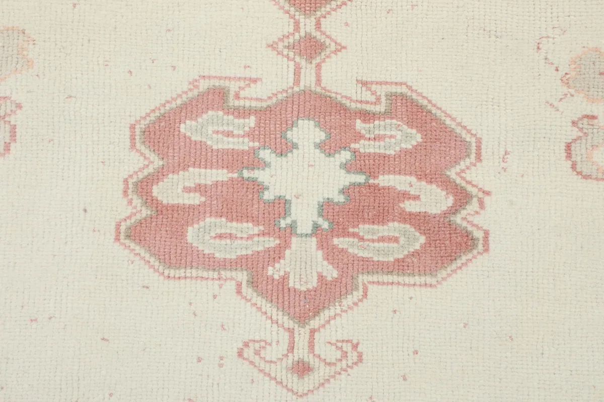 Detail of a secondary rose motif within the ivory field, showcasing the weaving and color.