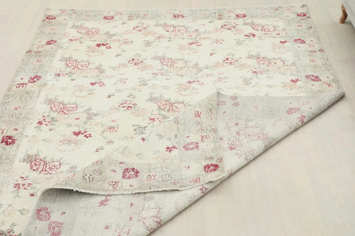 Rug partially folded, demonstrating its flexibility and the hand-knotted construction