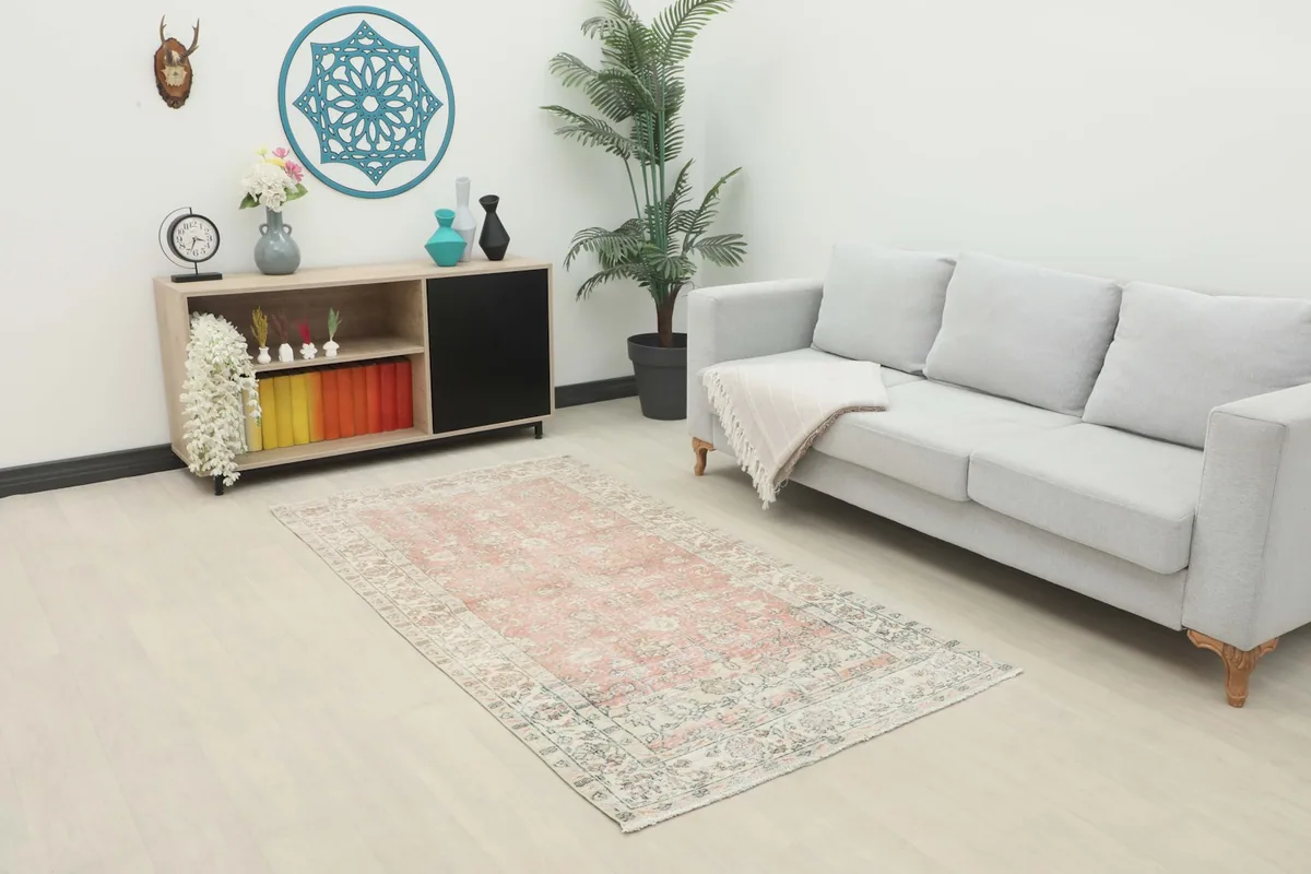 Vintage area rug displayed in a modern living room setting with a light gray sofa
