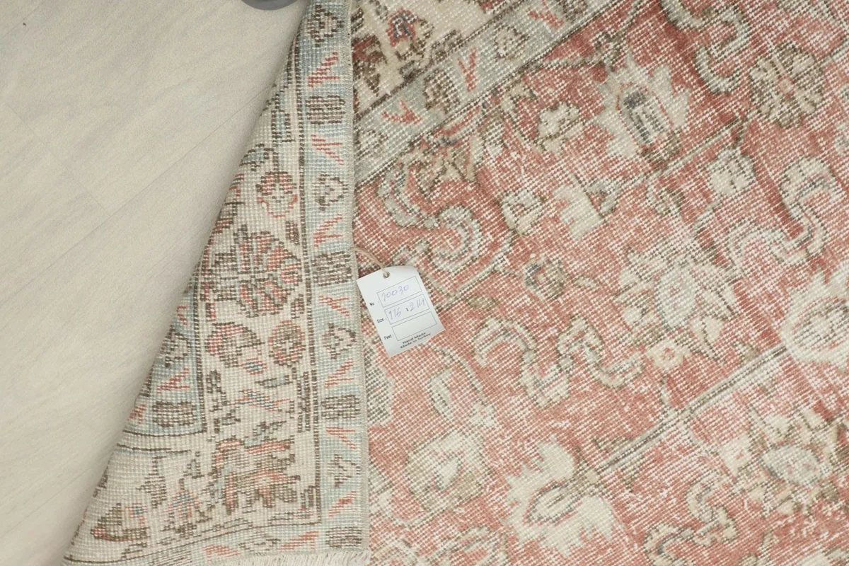 Another view of the rug's back, showing the craftsmanship and the label attached to the foundation