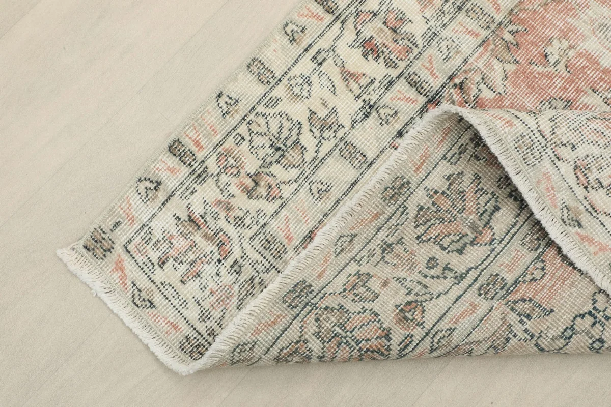 Corner of the rug folded back to show the thickness and flexibility of the hand-knotted wool