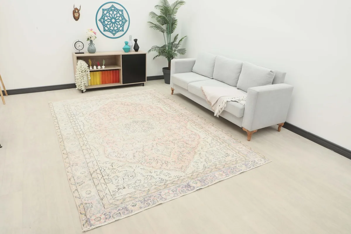 Vintage Anatolian rug displayed in a room setting with a light-colored sofa.