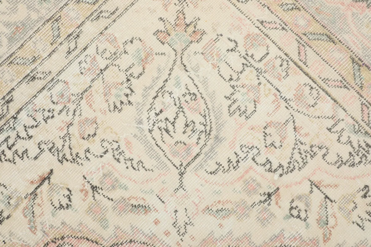 Close-up of the ivory field and floral details within the rug's design.