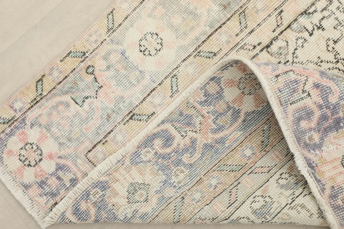 A folded corner of the rug, revealing the thickness and texture of the hand-knotted pile.