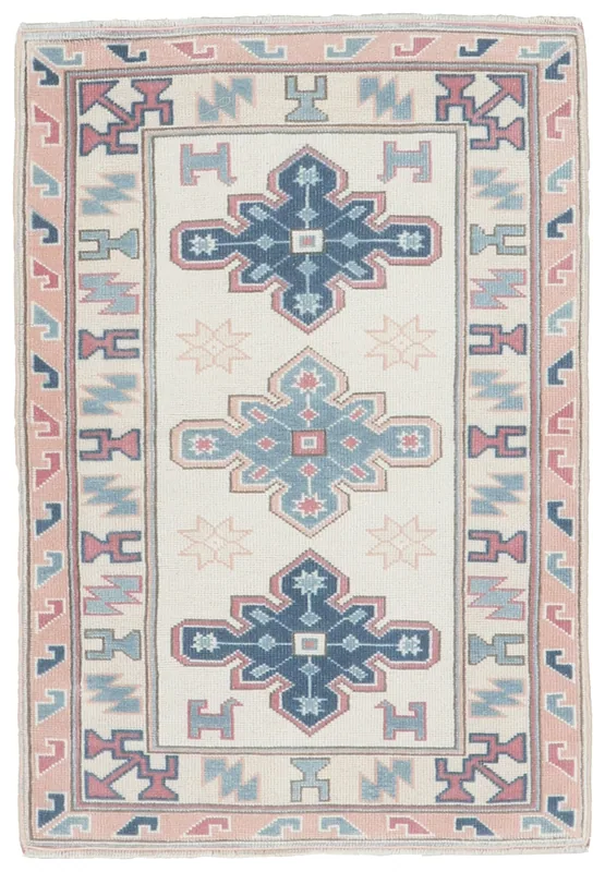 Full overhead view of the ivory, blue, and rose vintage Anatolian rug with geometric patterns