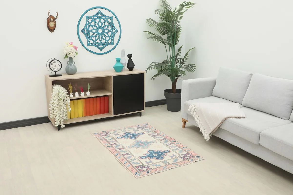 Vintage Anatolian rug displayed in a modern room setting, showing its scale next to a sofa and cabinet