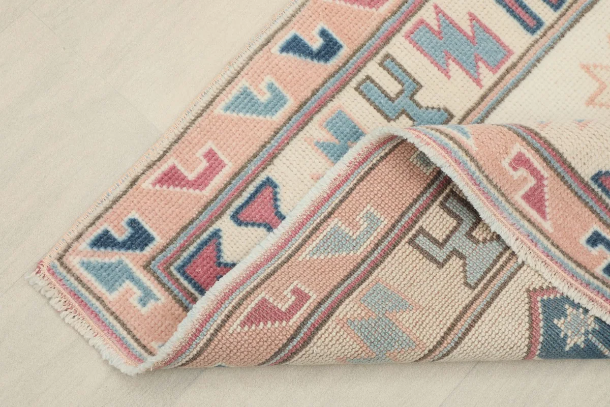Corner of the rug folded back, revealing the wool pile and cotton foundation