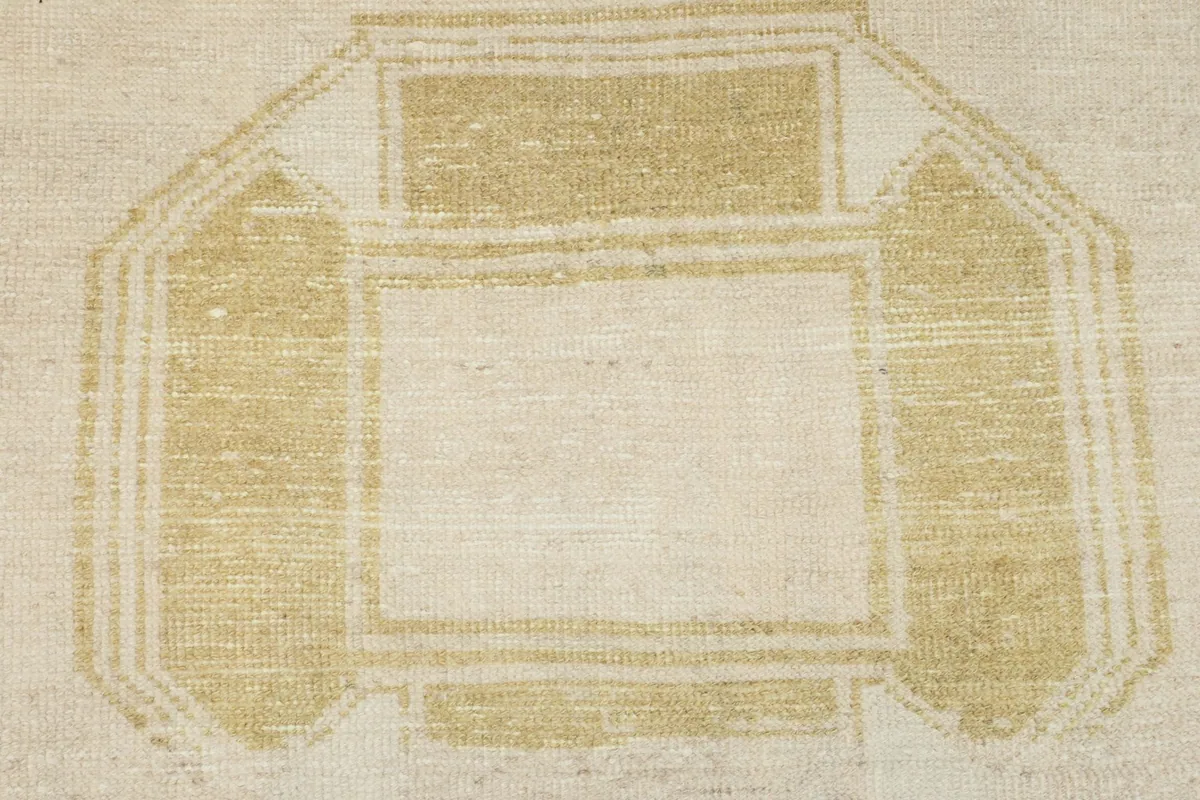 Macro view of the central gold geometric medallion motif, showcasing the wool pile texture.
