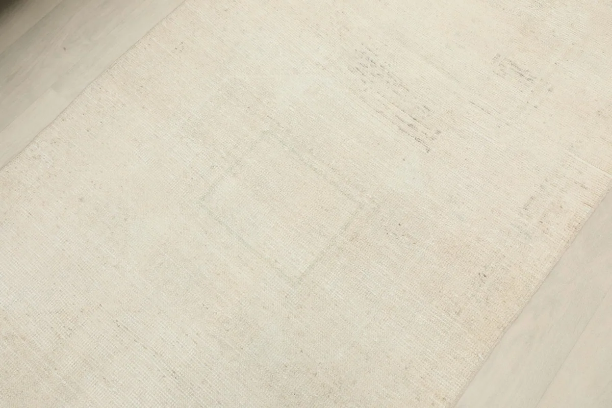 Detailed view of the low pile and subtle color variations across the ivory field of the runner rug.