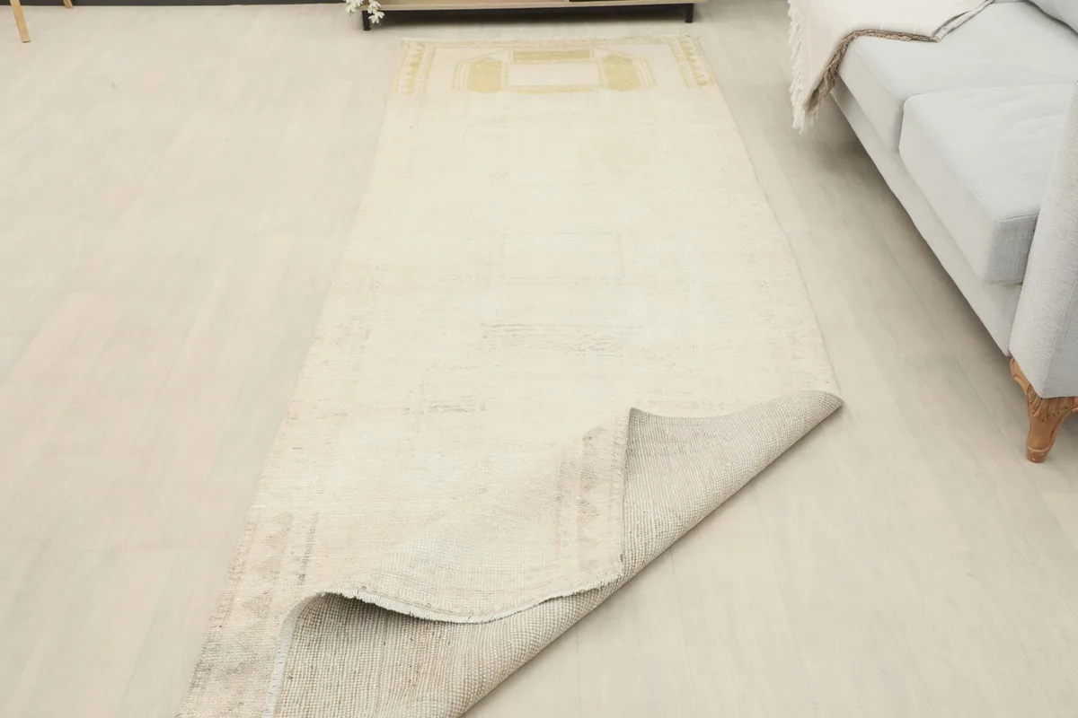 Runner rug partially folded, showing the flexibility and thickness of the wool pile and cotton foundation.