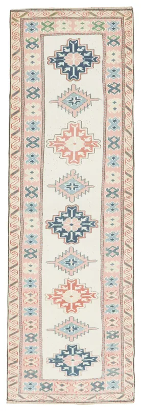 Full overhead view of the ivory, rose, blue, and orange geometric Anatolian runner on a white background.
