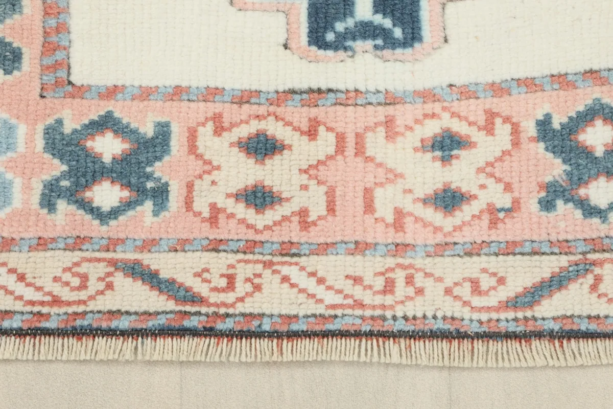 Close-up of the runner's intricate border design featuring rose, blue, and ivory patterns.