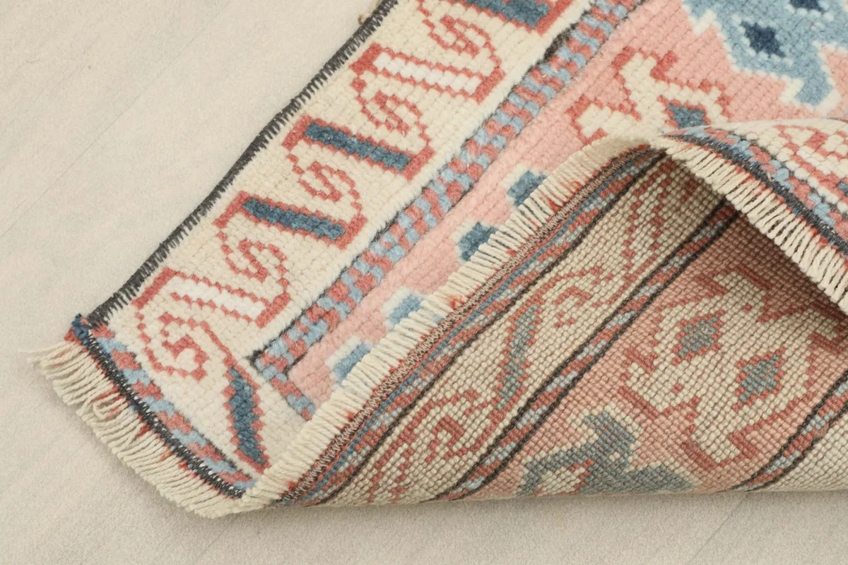 Corner of the runner folded to show the hand-knotted wool pile and cotton foundation from the reverse side.