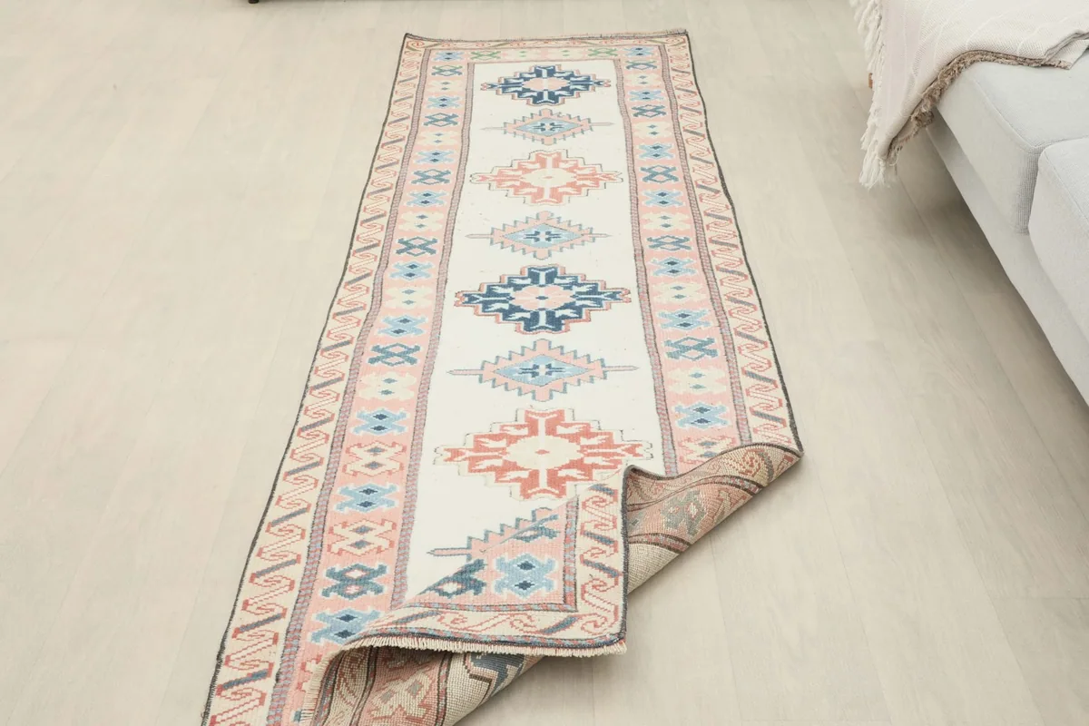 Runner partially folded, revealing the underside and confirming its hand-knotted construction and material.