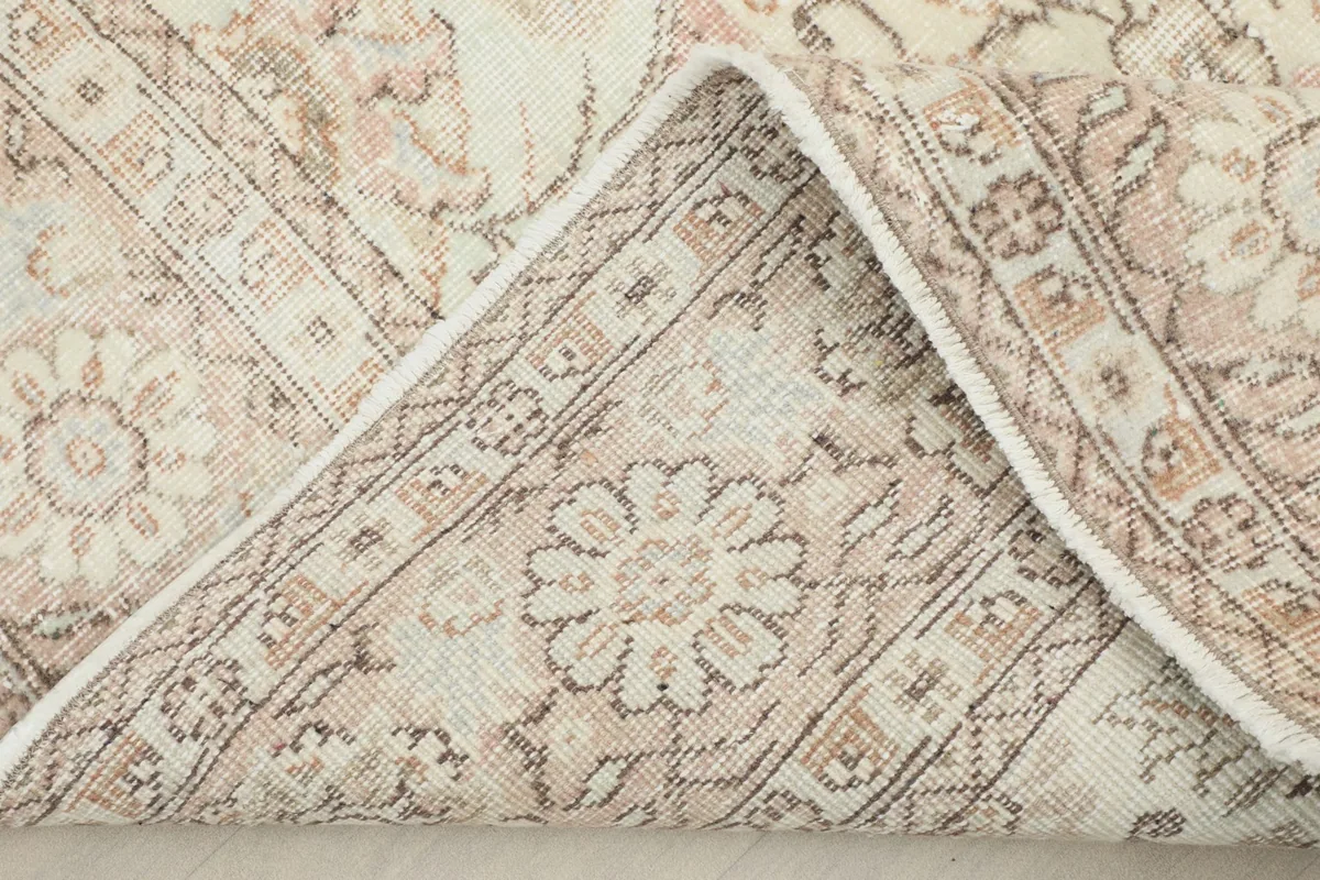 View of the rug's underside, revealing the hand-knotted cotton foundation and wool pile.