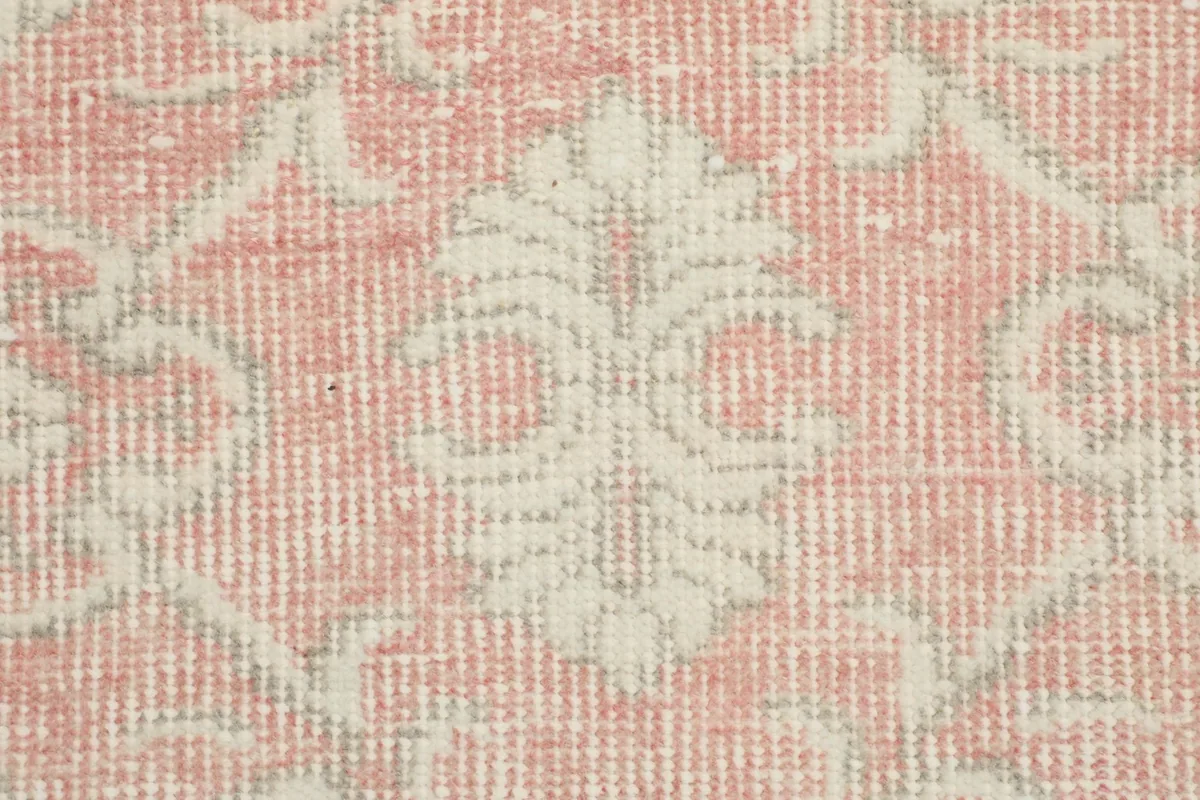 Macro view of the hand-knotted wool pile and cotton foundation, showing texture and color