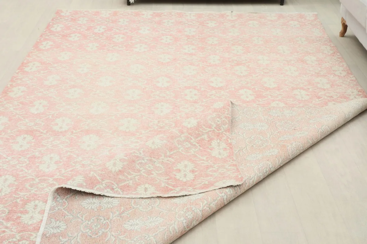 Partial view of the rug with a corner folded over, showing the underside and construction