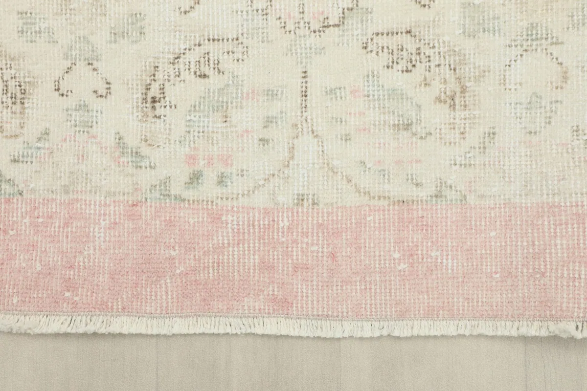 Close-up of the rose border and the transition to the ivory field, showing the rug's edge and fringe