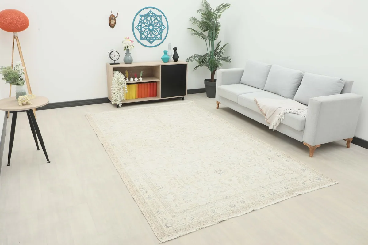 Ivory vintage rug placed in a living room setting with a light gray sofa