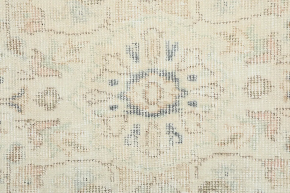 Detailed view of the hand-knotted wool pile, showing faded blue and tan accents