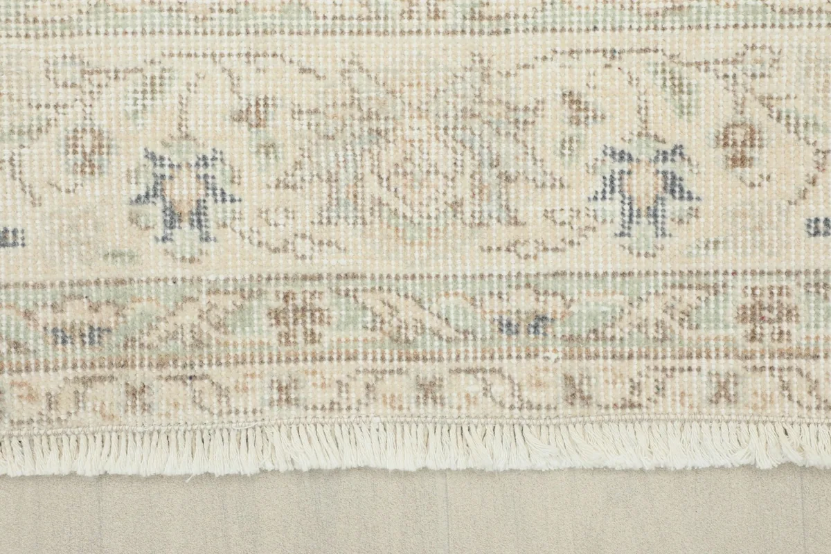 Close-up of the rug's border design and short, hand-knotted fringe