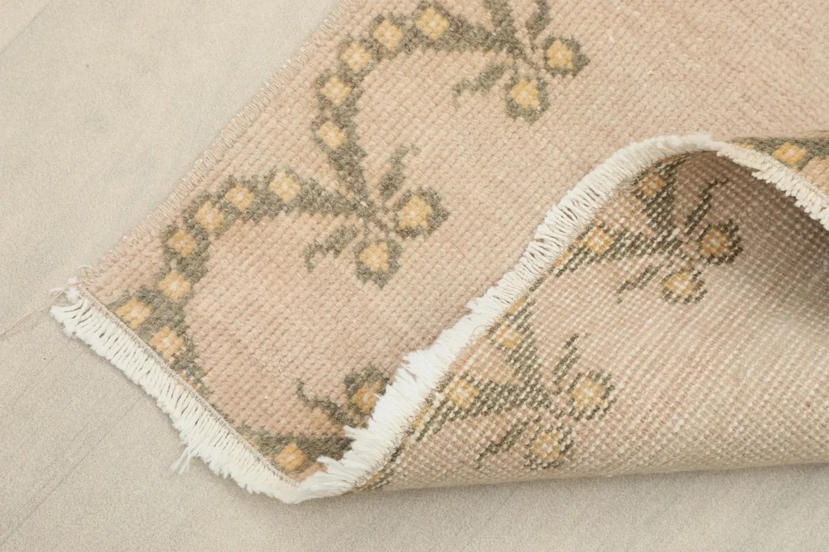 Corner of the runner rug folded to show the hand-knotted wool pile on cotton foundation from the back.