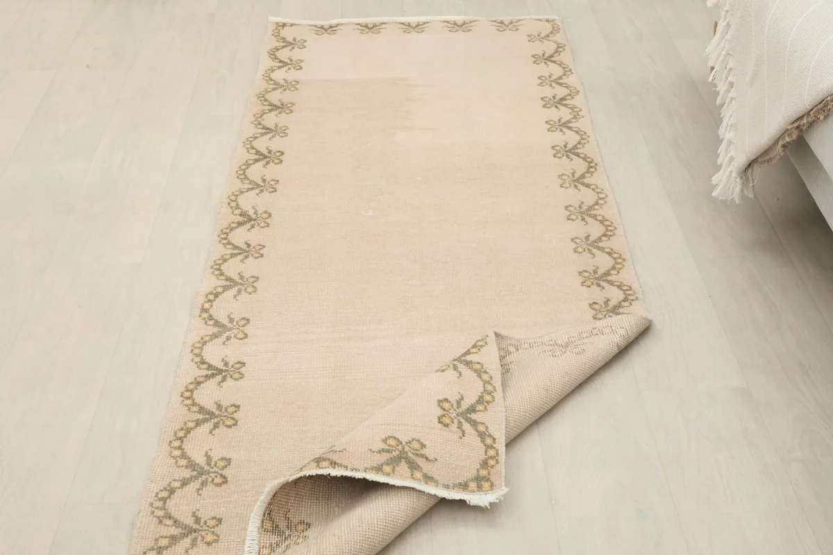 Angled view of the runner rug with a corner folded back, revealing the reverse side and construction.