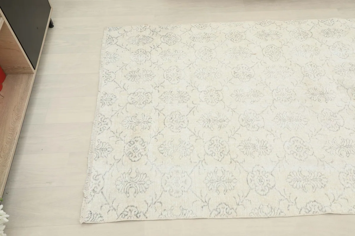 Close-up angled view of the ivory and gray rug's surface and design details