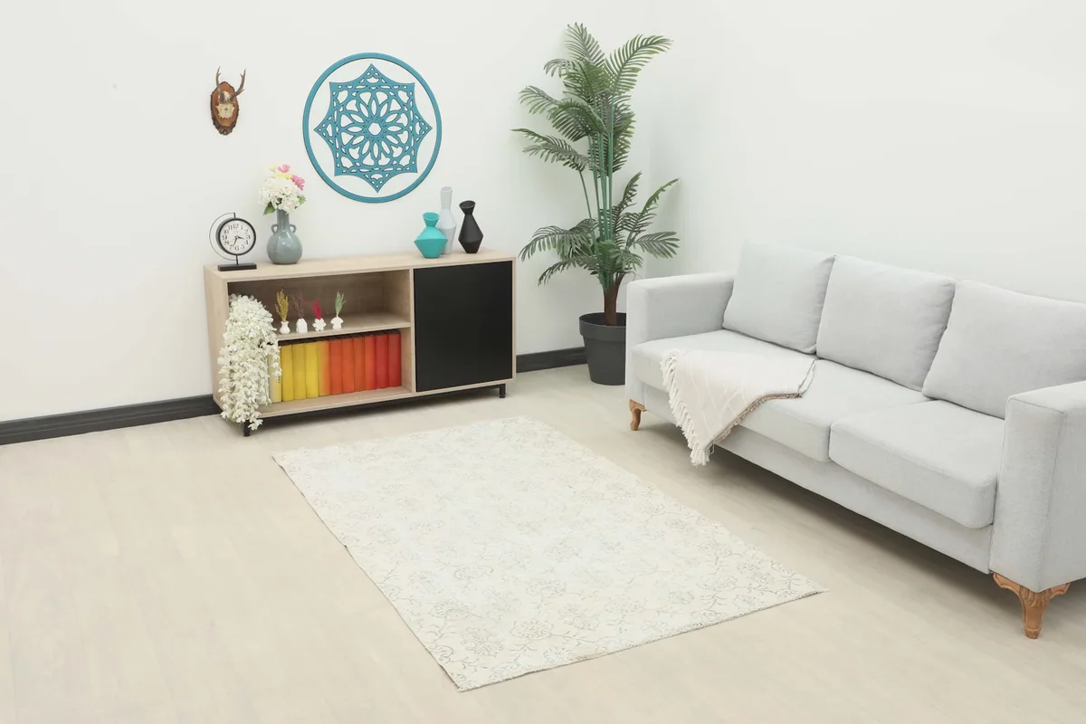 Ivory and gray vintage rug placed in a modern living room setting with a light gray sofa