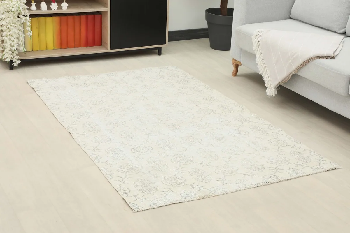 Overhead view of the ivory and gray vintage rug in a living room, showing its full size