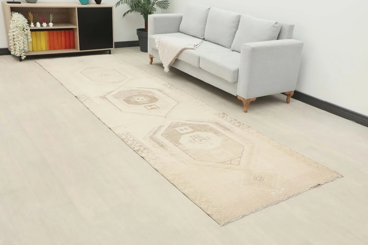 Angled view of the beige and gray runner rug extending down a hallway towards a sofa