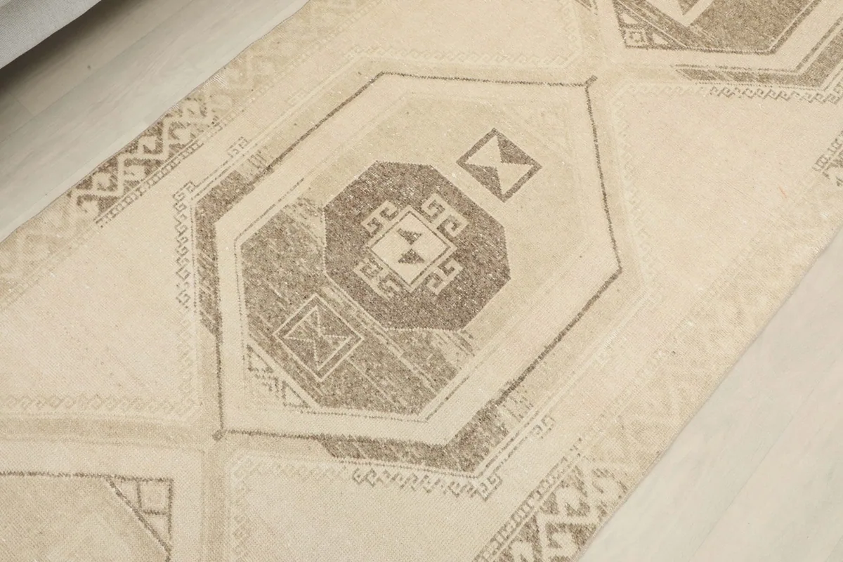 Close-up showing the central geometric medallion and surrounding tribal patterns in beige and gray tones