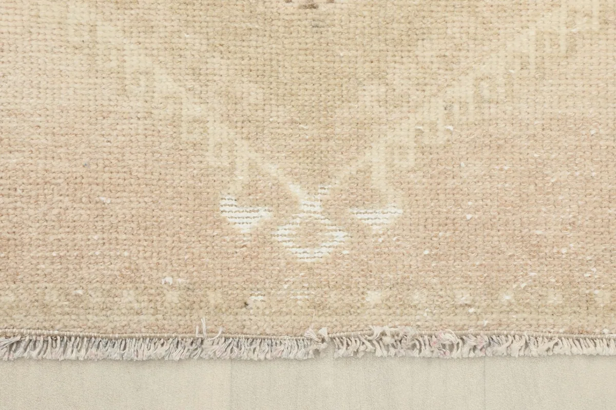 Detail of the short, worn fringe and edge finishing of the vintage runner rug