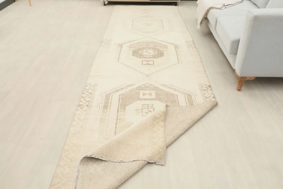 Runner rug partially folded in a room setting, revealing the back and thickness