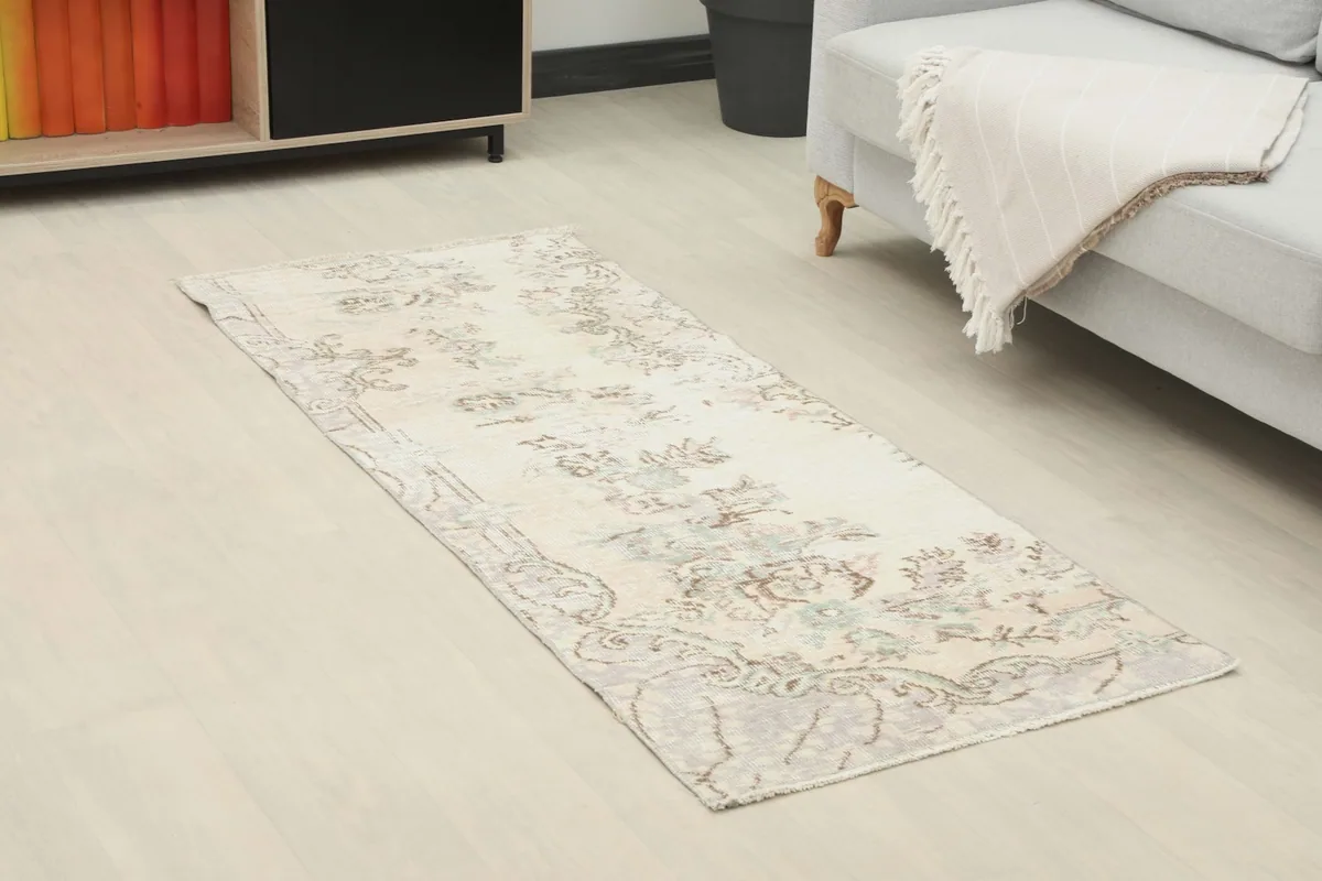 Angled view of the ivory runner in a modern living space, showing its placement in front of a sofa.