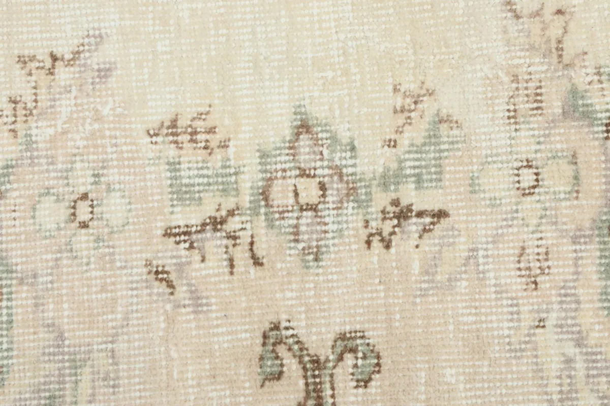 Macro detail of the distressed wool pile, revealing the intricate knotting and color variations in the rug.