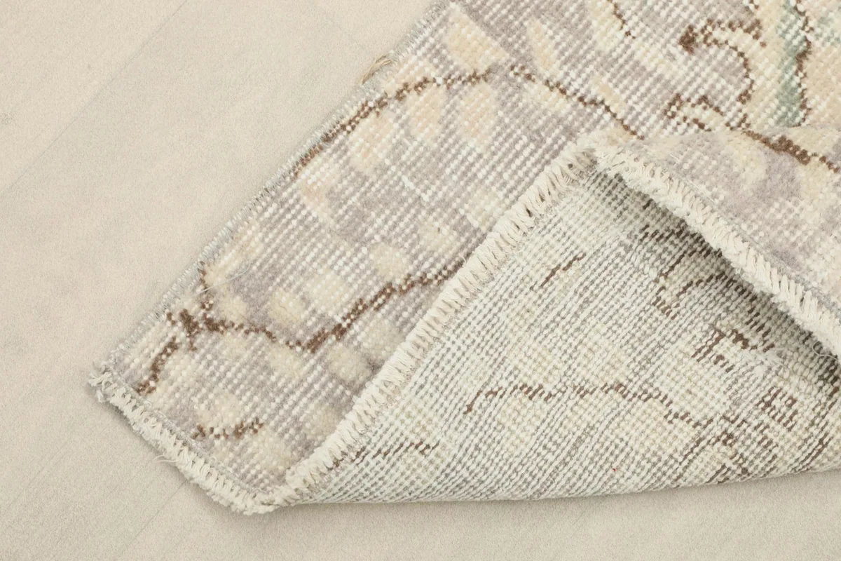 View of the back of the hand-knotted rug, showing the cotton foundation and the reverse of the pattern.
